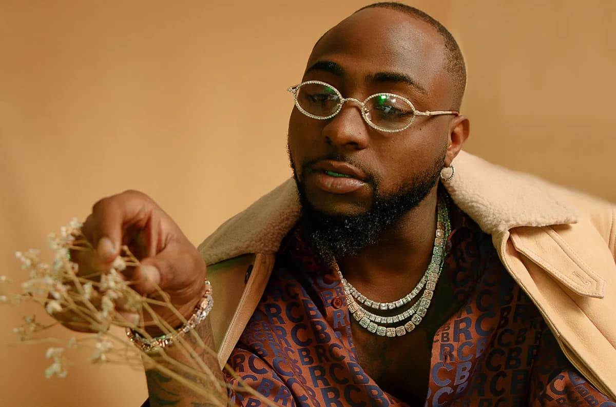 Editorial gallery of Davido styled in bold winter ensembles mixing neon pops, inky black, and chrome sparkle, highlighting ultra violet, neon fuchsia, electric jade, polished pewter, and onyx.