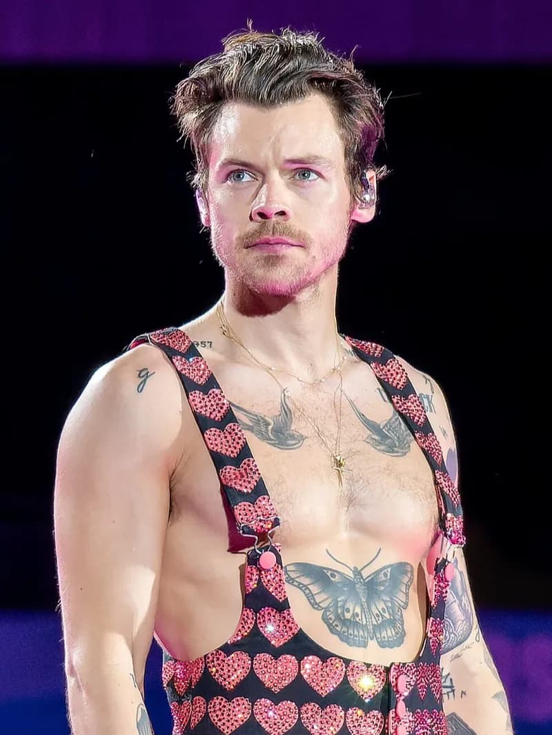 Harry Styles wearing luminous spring outfits with juicy warm hues, showcasing papaya orange, sunny marigold, aqua turquoise, creamy ivory, and rose gold from the Warm Spring palette.