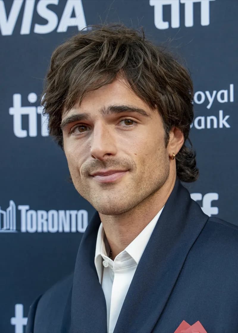 Jacob Elordi wearing grounded autumn looks with rich neutrals and subtle shimmer, showcasing cedar brown, sage moss, warm taupe, terracotta, and antique gold from the Neutral Autumn palette.