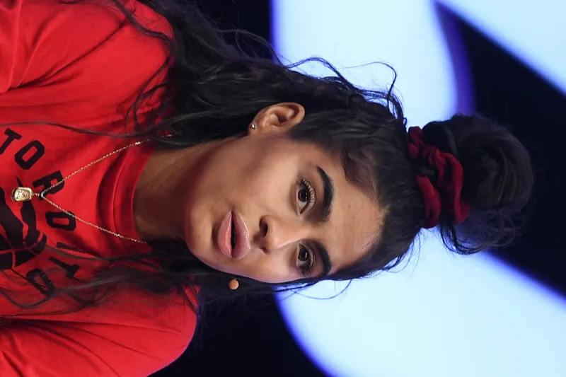 Jessie Reyez wearing luminous spring outfits with juicy warm hues, showcasing papaya orange, sunny marigold, aqua turquoise, creamy ivory, and rose gold from the Warm Spring palette.