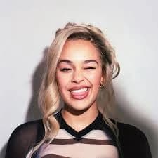Editorial gallery of Jorja Smith styled in bright winter looks with electric blues, magenta accents, and polished black, highlighting electric cobalt, icy magenta, optic white, chrome silver, and inky black.