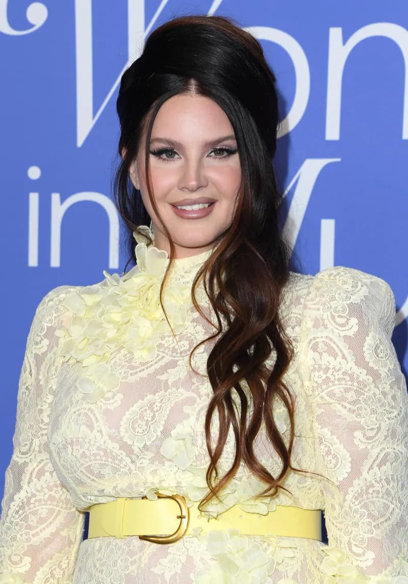 Lana Del Rey wearing muted autumn ensembles with velvety textures and gentle warmth, showcasing desert rose, sage green, oatmeal, copper brown, and soft teal from the Soft Autumn palette.