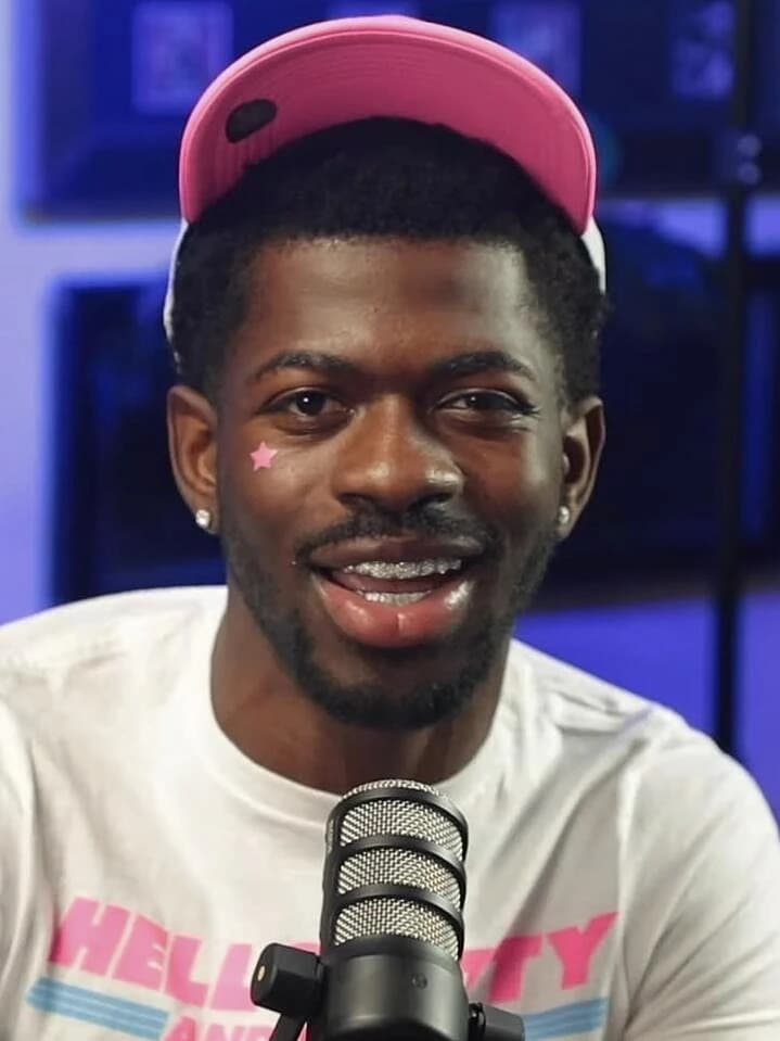 Lil Nas X wearing jewel-toned statement dressing with crisp contrast and sparkle, showcasing electric cobalt, icy magenta, optic white, chrome silver, and inky black from the Bright Winter palette.
