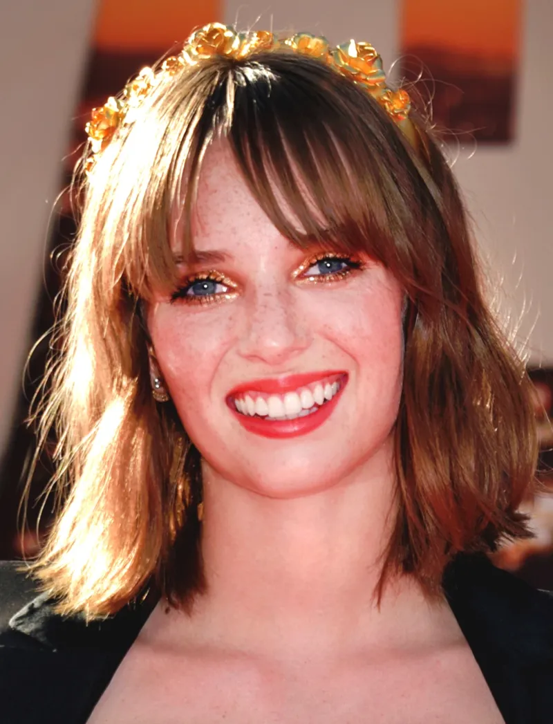 Maya Hawke wearing luminous spring outfits with juicy warm hues, showcasing papaya orange, sunny marigold, aqua turquoise, creamy ivory, and rose gold from the Warm Spring palette.