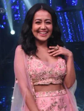 Neha Kakkar wearing saturated autumn looks with molten metallics, showcasing sunset coral, electric apricot, teal flash, buttery ivory, and gold shimmer from the Vibrant Autumn palette.