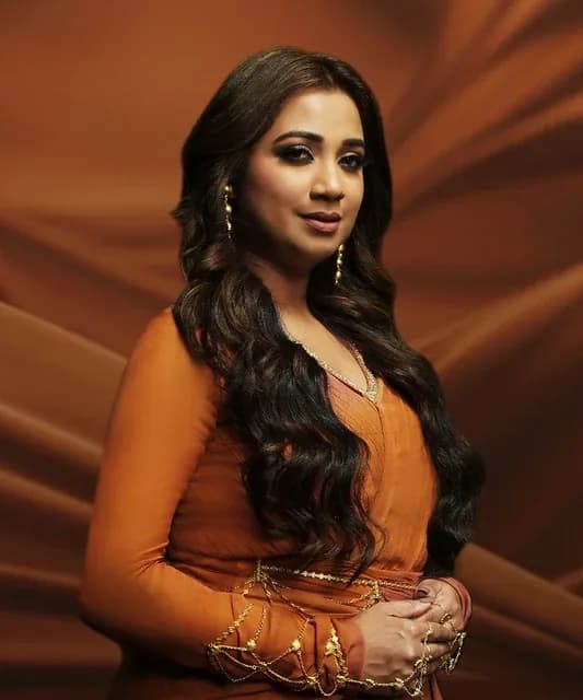 Editorial gallery of Shreya Ghoshal styled in soft autumn looks mixing moss green, terracotta, and bronzed neutrals, highlighting warm rose, muted teal, honey beige, sage, and antique gold.