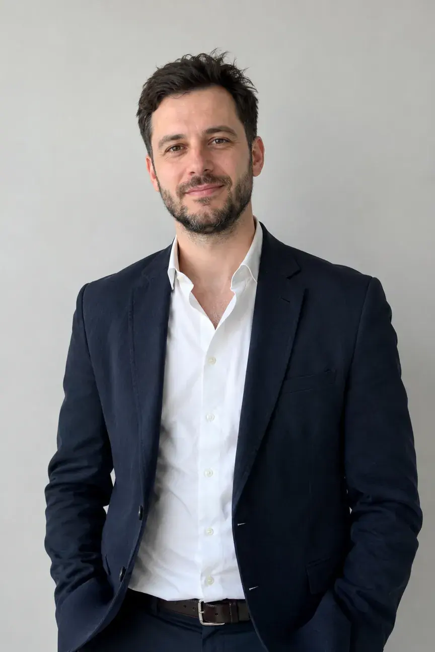 Man with cool, high-contrast coloring wearing a navy blazer and white shirt