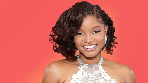 Halle Bailey wearing luminous spring outfits with juicy warm hues, showcasing seafoam, sunset coral, aqua, gold shimmer, and shell pink from the Warm Spring palette.