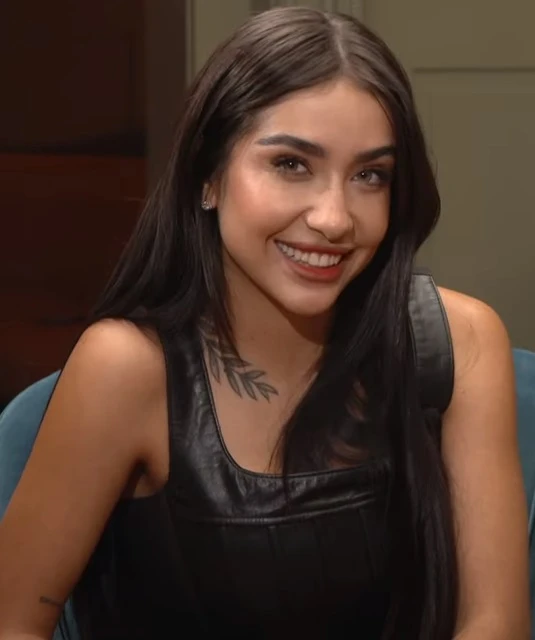 Maria Becerra wearing jewel-toned statement dressing with crisp contrast and sparkle, showcasing electric cobalt, icy magenta, optic white, chrome silver, and inky black from the Bright Winter palette.