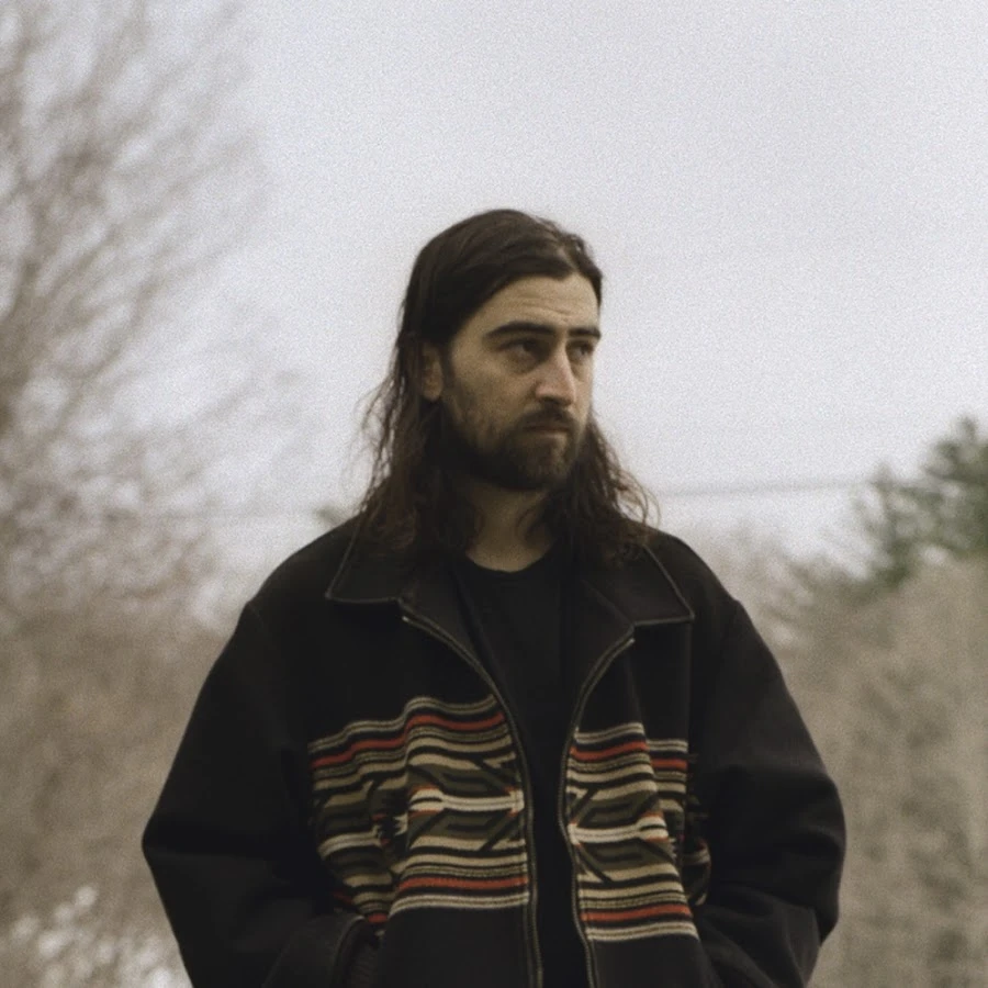 Noah Kahan wearing sunshine pastel outfits with fluid fabric and glow, showcasing sherbet peach, sea glass, buttermilk, mint foam, and rose coral from the Light Spring palette.