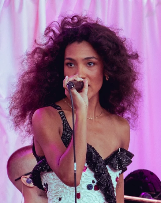 Olivia Dean wearing velvety pastel looks with cool-muted tones, showcasing heather gray, dusty mauve, mist blue, slate green, and antique silver from the Soft Summer palette.