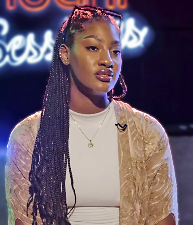 Tems wearing jewel-toned statement dressing with crisp contrast and sparkle, showcasing electric cobalt, icy magenta, optic white, chrome silver, and inky black from the Bright Winter palette.